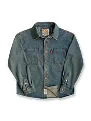 製品画像
「ウォッシュ加工を施したクラシックなワークデニムシャツ全体のイメージ。シンプルなデザインと自然なユーズド感が特徴で、通勤から日常使いまで幅広く活躍。」

詳細画像
「左右対称のフロントダブルポケットとウォッシュ加工されたデニム素材のディテールをクローズアップ。上質なコットン100%生地の柔らかい肌触りが魅力。」
