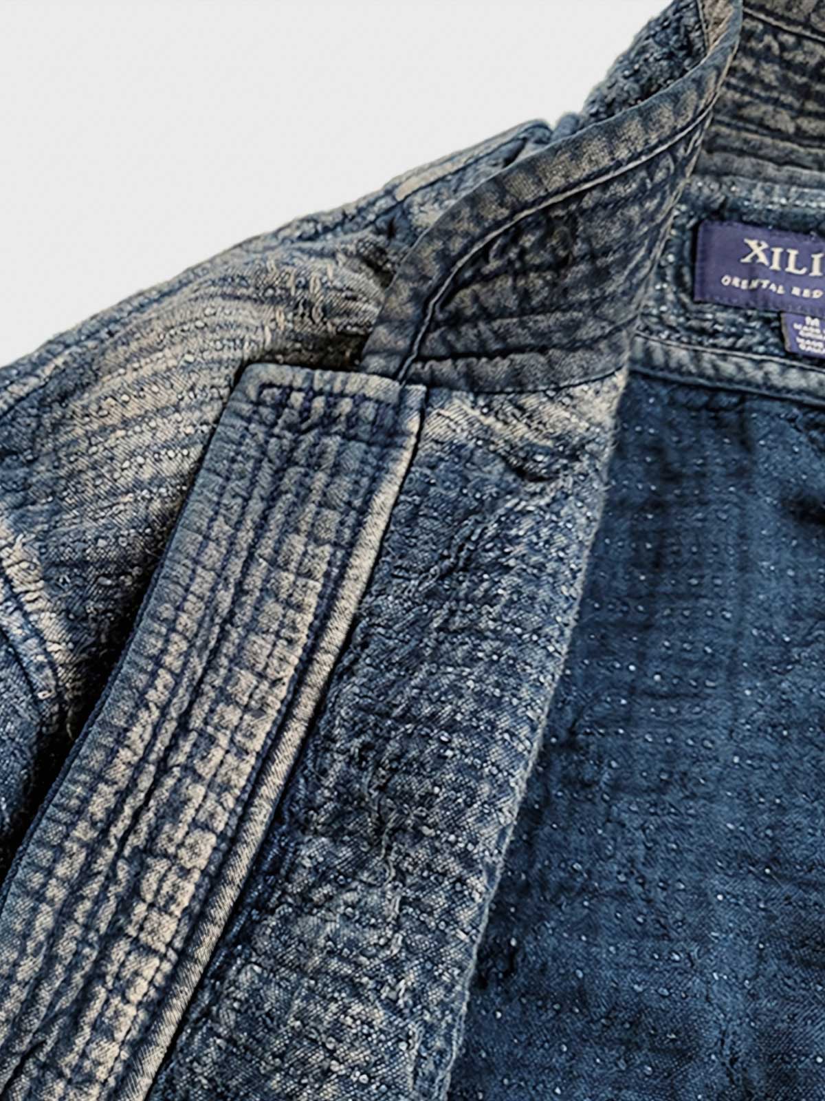 製品画像: Indigo 藍染め スタンドカラーチャイナボタン コート全体写真。藍染め技法とストーンウォッシュ加工が際立つ、東洋の美学とヴィンテージスタイルを融合したデザイン。
詳細画像: チャイナボタンのクラシックなディテールとストーンウォッシュ加工による深みのある藍色を強調した写真。