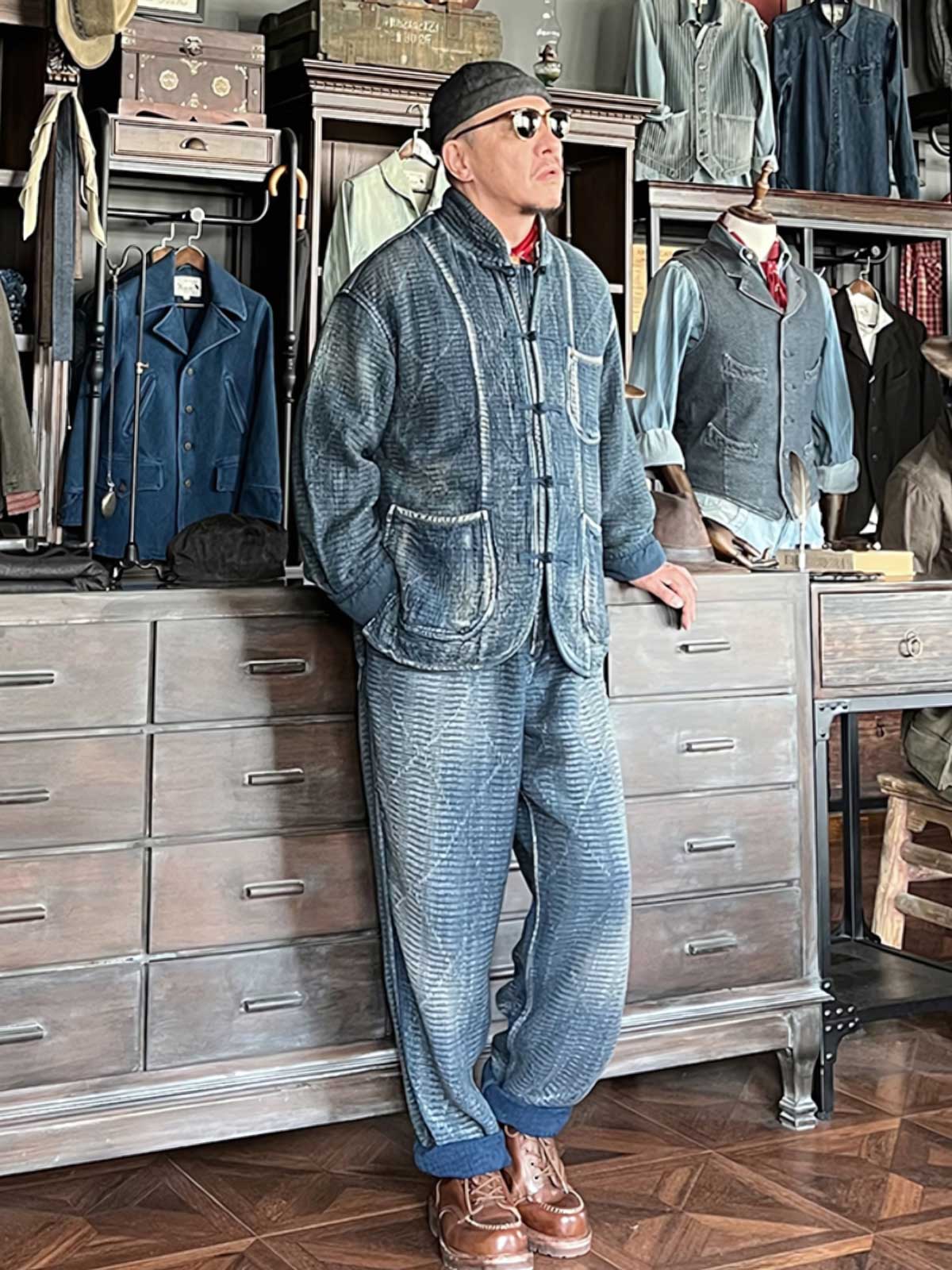 詳細画像: チャイナボタンのクラシックなディテールとストーンウォッシュ加工による深みのある藍色を強調した写真。
モデル画像: Indigo 藍染め スタンドカラーチャイナボタン コートを着用したモデルによる、洗練されたヴィンテージスタイルのコーディネート写真。