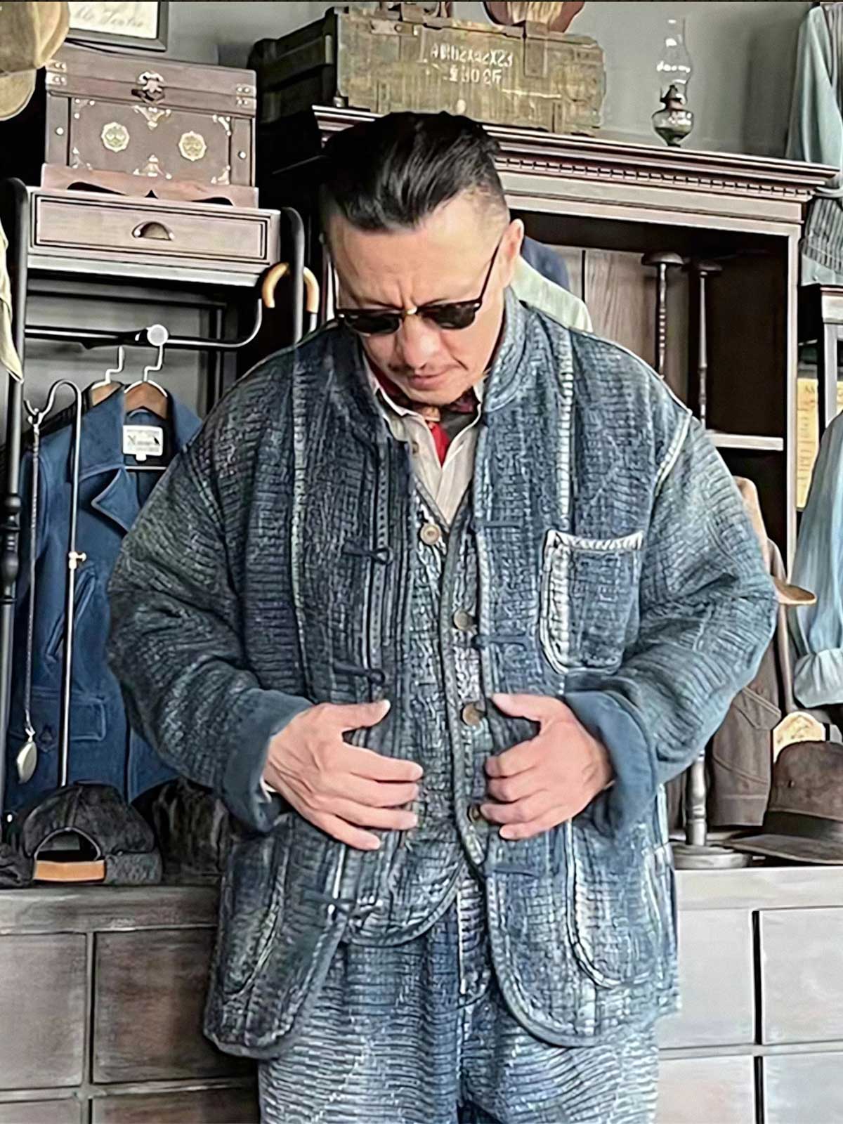 詳細画像: チャイナボタンのクラシックなディテールとストーンウォッシュ加工による深みのある藍色を強調した写真。
モデル画像: Indigo 藍染め スタンドカラーチャイナボタン コートを着用したモデルによる、洗練されたヴィンテージスタイルのコーディネート写真。