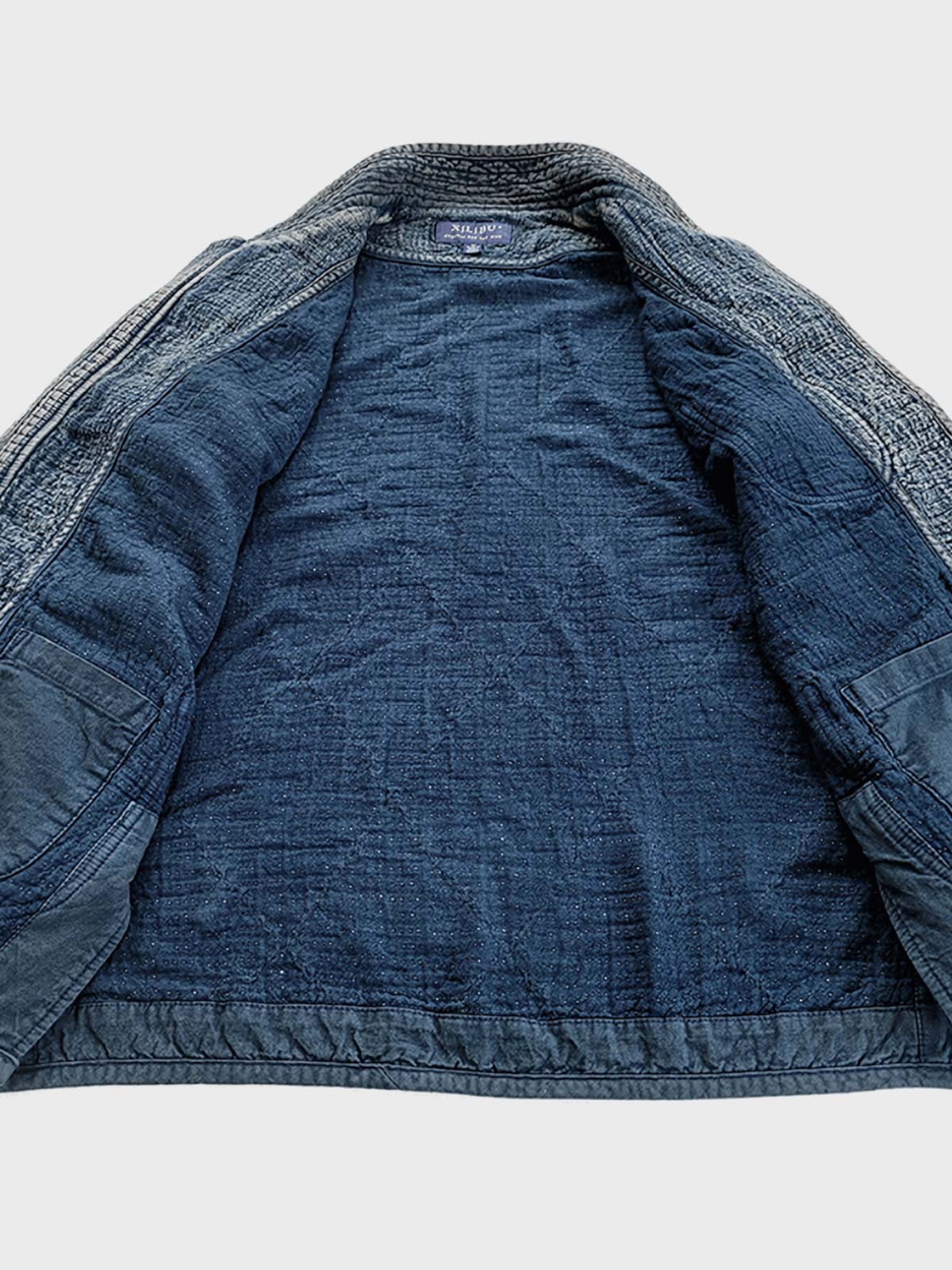 製品画像: Indigo 藍染め スタンドカラーチャイナボタン コート全体写真。藍染め技法とストーンウォッシュ加工が際立つ、東洋の美学とヴィンテージスタイルを融合したデザイン。
詳細画像: チャイナボタンのクラシックなディテールとストーンウォッシュ加工による深みのある藍色を強調した写真。