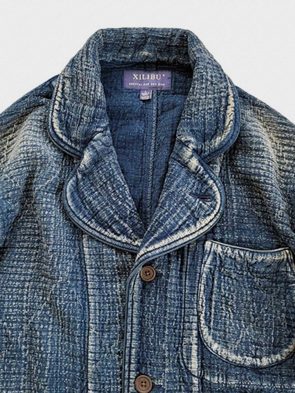 製品画像: Indigo 藍染め 刺子織り カジュアルブレザー全体写真。天然植物藍染めと刺子織りの伝統工芸が際立つヴィンテージスタイルのブレザー。
詳細画像: 刺子織りのピースワークデザインと天然本牛角ボタンの高品質ディテールを強調した写真。深みのある藍色が特徴。