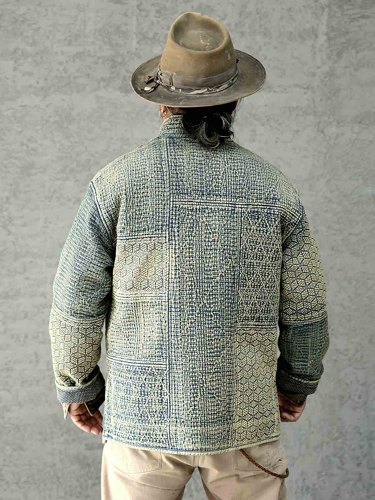 詳細画像: 刺子織りの繊細なテクスチャと藍染めの深みある色合いを強調したディテール写真。水洗抜染加工による個性的な風合いを表現。
モデル画像: 藍染め刺子織りスタンドカラージャケットを着用したモデルによる、レトロで上品なスタイリング写真。