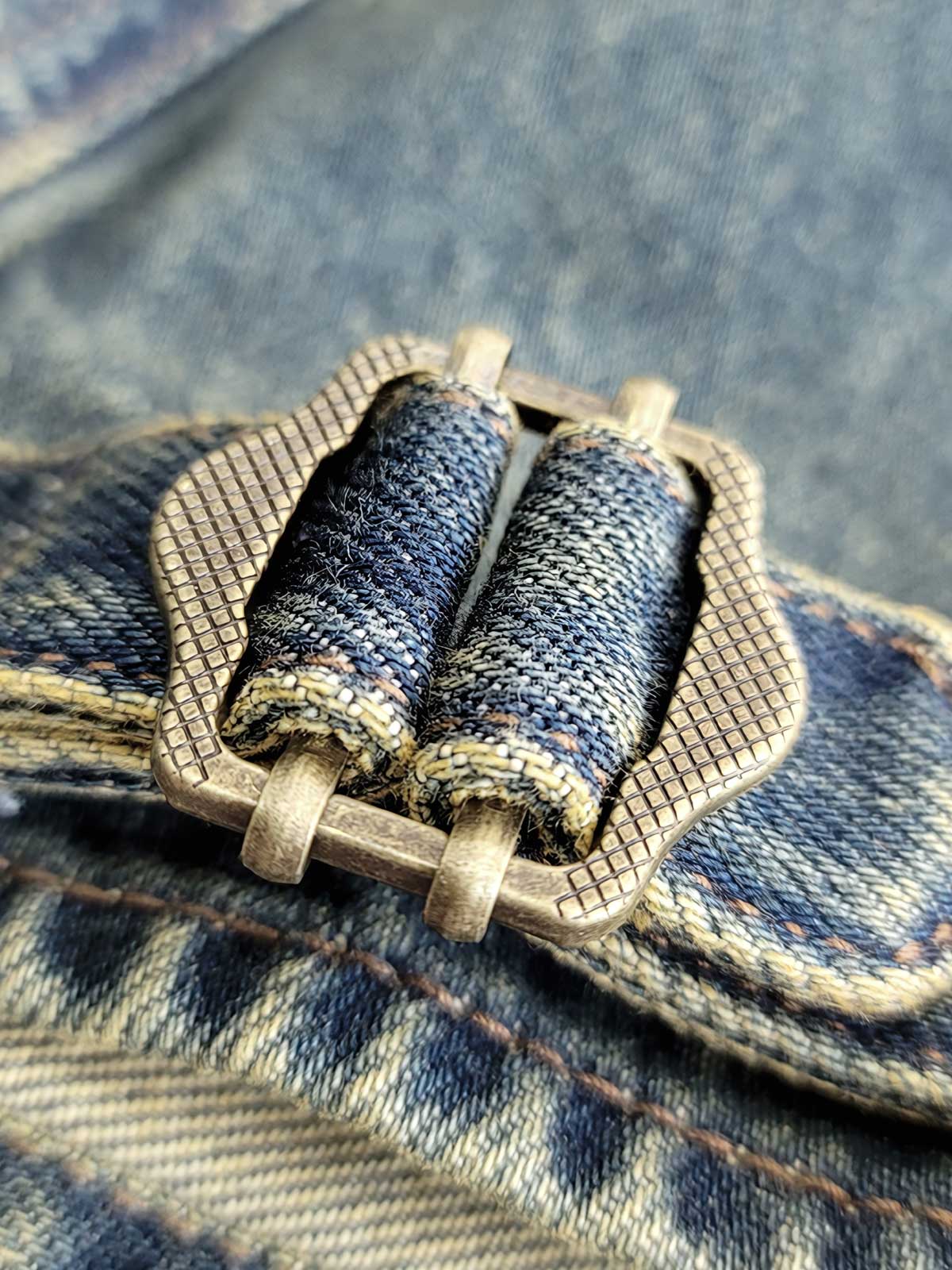 バンドカラーデニムジャケット、ブリーチウォッシュでヴィンテージスタイルを強調、フロントにダブルポケット付きディテールクローズアップ：バンドカラーデニムジャケットの耐久性のあるデニム素材と精密な縫製技術、ブリーチウォッシュ加工の詳細