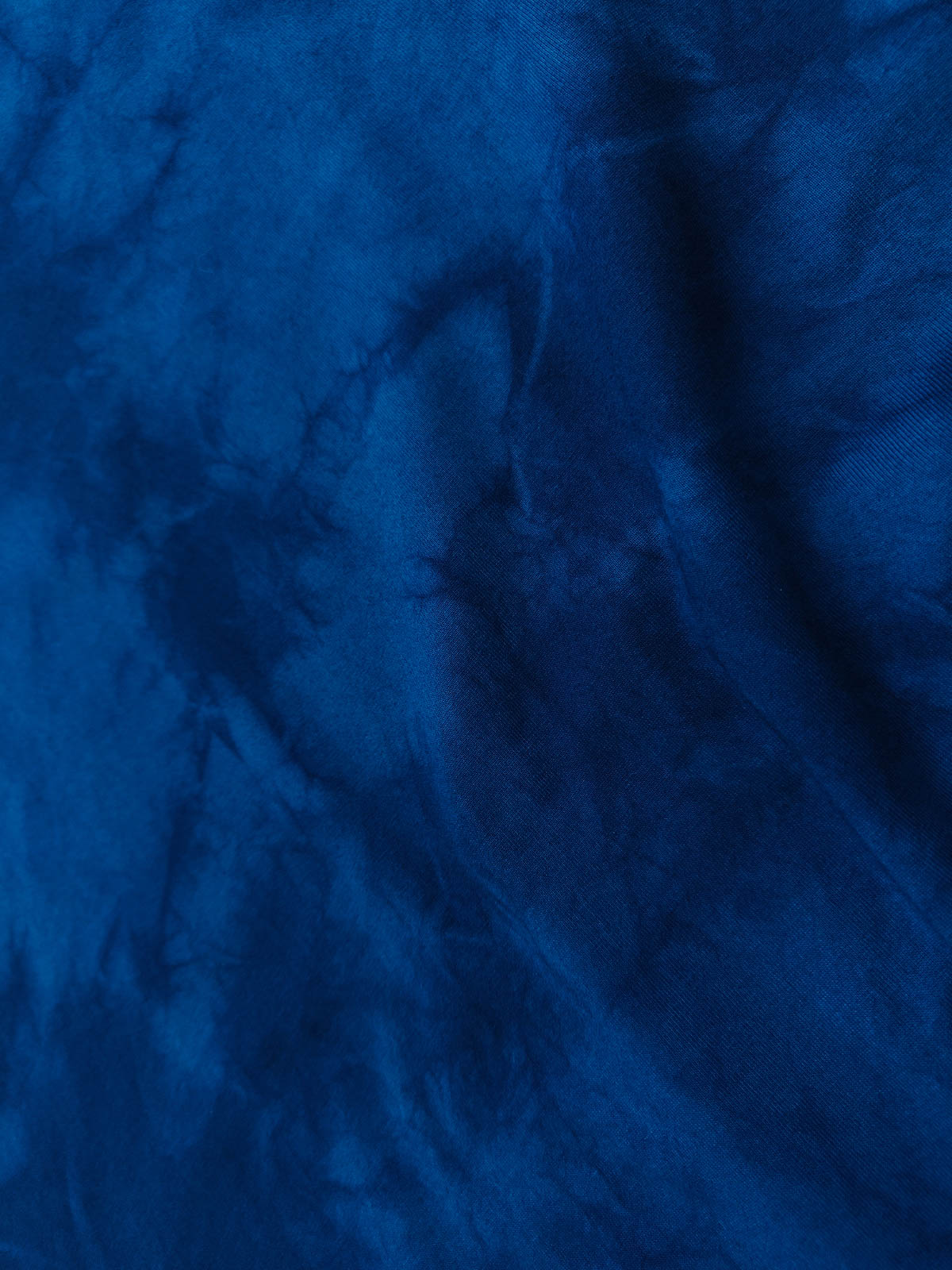 氷紋絞り染めTシャツのクローズアップ、個々の染め模様が繊細なアートワークを展示。