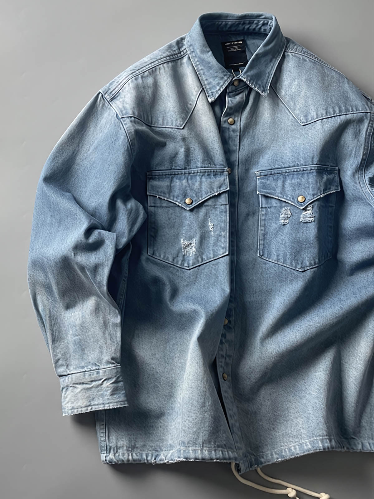 製品画像: 古着風加工の破れ水洗いヴィンテージデニムシャツ正面画像、ヴィンテージ感が際立つ。
詳細画像: ワークポケットと摩耗加工のディテール画像、クラシックな雰囲気を強調。