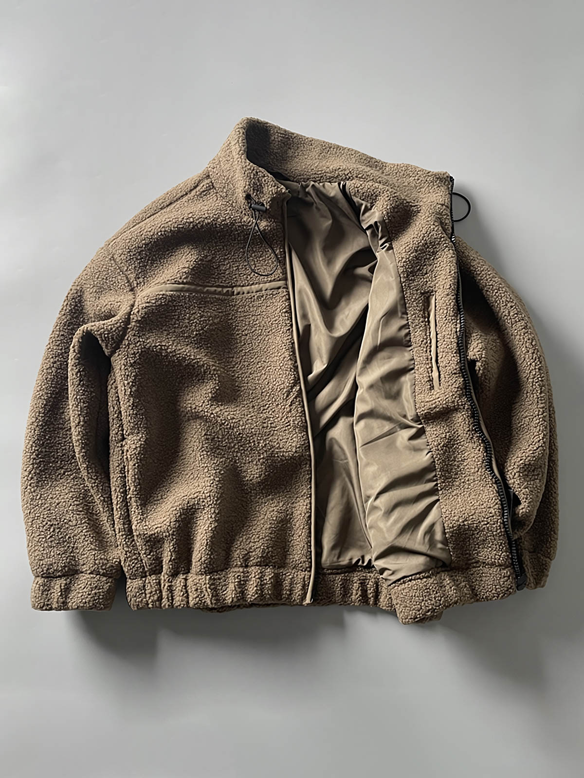 製品画像: ボアフリーススタンドカラージャケットの全体画像、アウトドアやカジュアルスタイルに対応。
詳細画像: 胸元ジッパーポケットのディテール画像、実用性とデザイン性を強調。