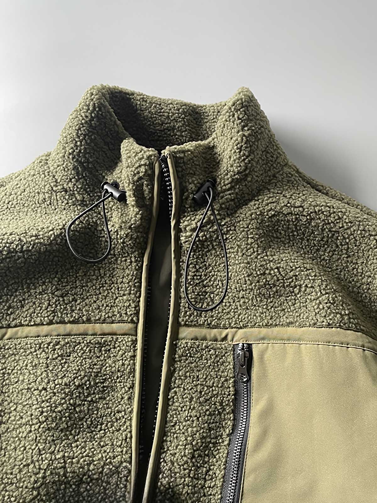 製品画像: ボアフリーススタンドカラージャケットの全体画像、アウトドアやカジュアルスタイルに対応。
詳細画像: 胸元ジッパーポケットのディテール画像、実用性とデザイン性を強調。