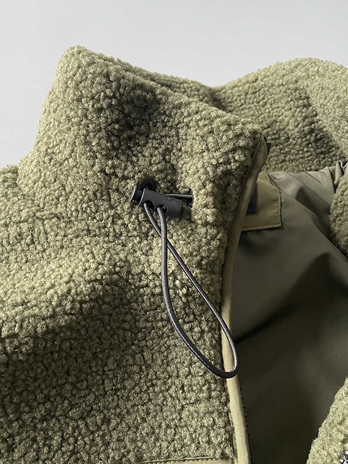 製品画像: ボアフリーススタンドカラージャケットの全体画像、アウトドアやカジュアルスタイルに対応。
詳細画像: 胸元ジッパーポケットのディテール画像、実用性とデザイン性を強調。