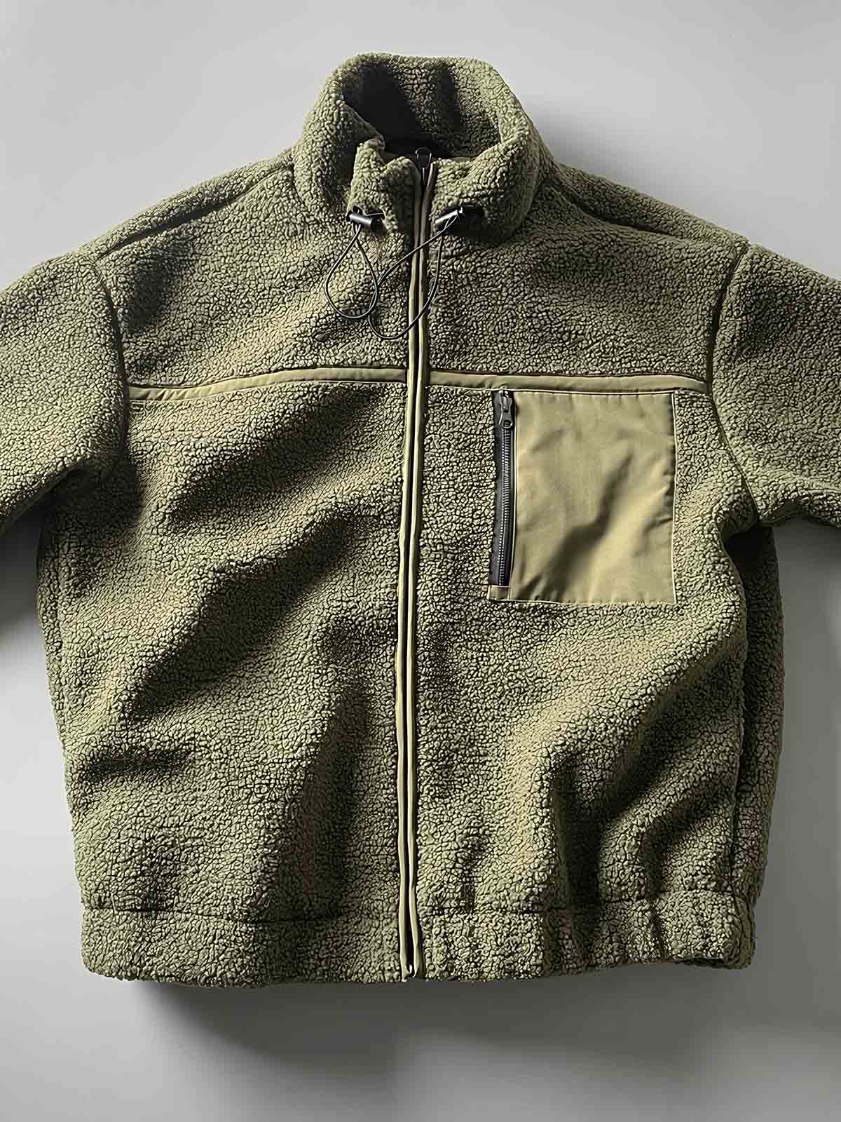 製品画像: ボアフリーススタンドカラージャケットの全体画像、アウトドアやカジュアルスタイルに対応。
詳細画像: 胸元ジッパーポケットのディテール画像、実用性とデザイン性を強調。