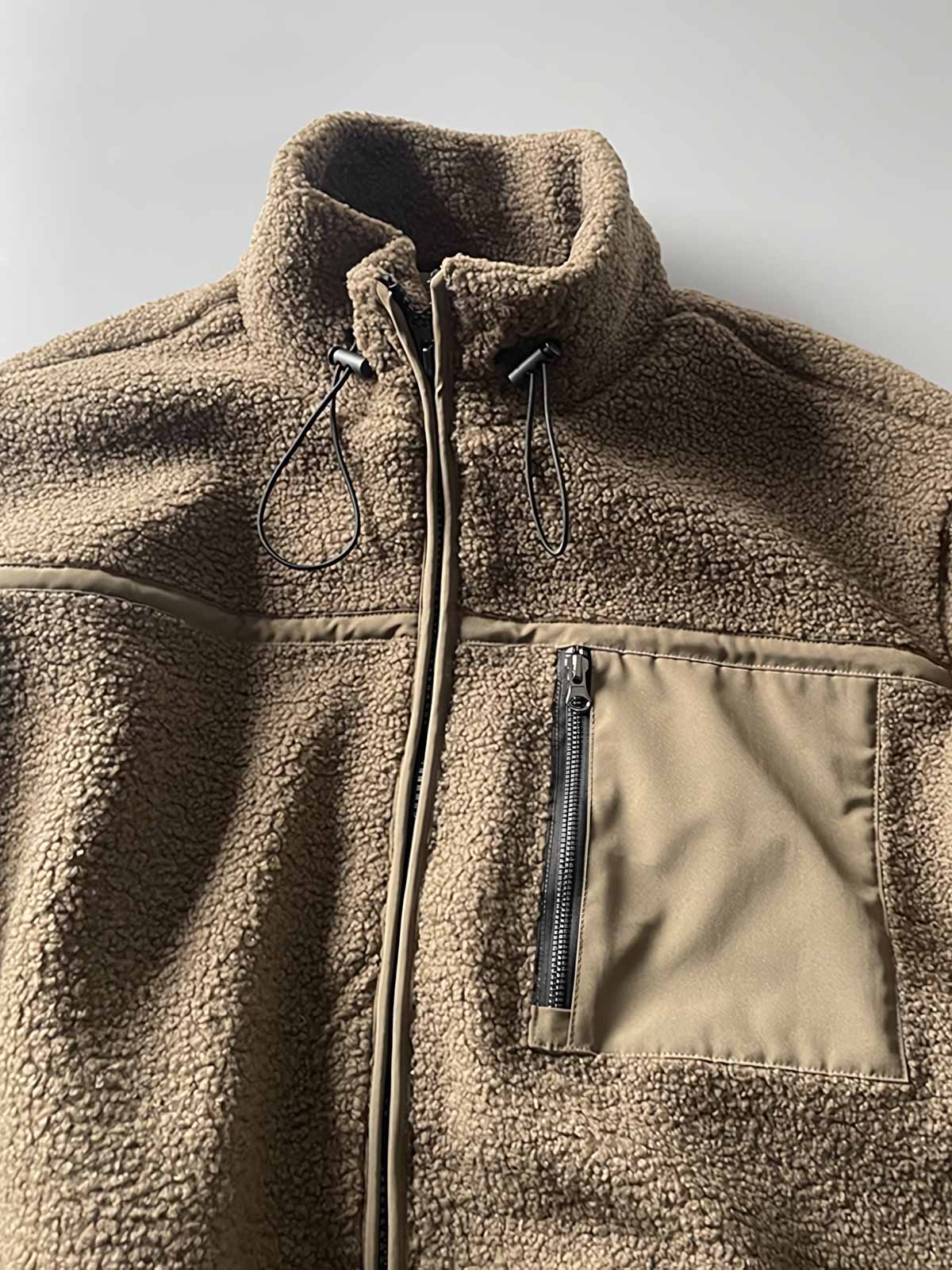 製品画像: ボアフリーススタンドカラージャケットの全体画像、アウトドアやカジュアルスタイルに対応。
詳細画像: 胸元ジッパーポケットのディテール画像、実用性とデザイン性を強調。