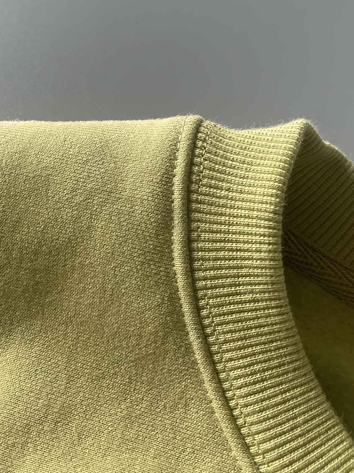 製品画像: ライムイエロー起毛裏起毛スウェットシャツの正面画像、快適で暖かいデザインが特徴。
詳細画像: 胸ポケットと起毛生地のディテール画像、柔らかな質感が際立つ。