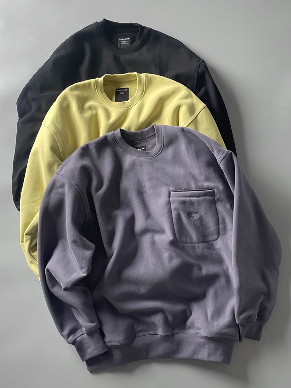 製品画像: ライムイエロー起毛裏起毛スウェットシャツの正面画像、快適で暖かいデザインが特徴。
詳細画像: 胸ポケットと起毛生地のディテール画像、柔らかな質感が際立つ。