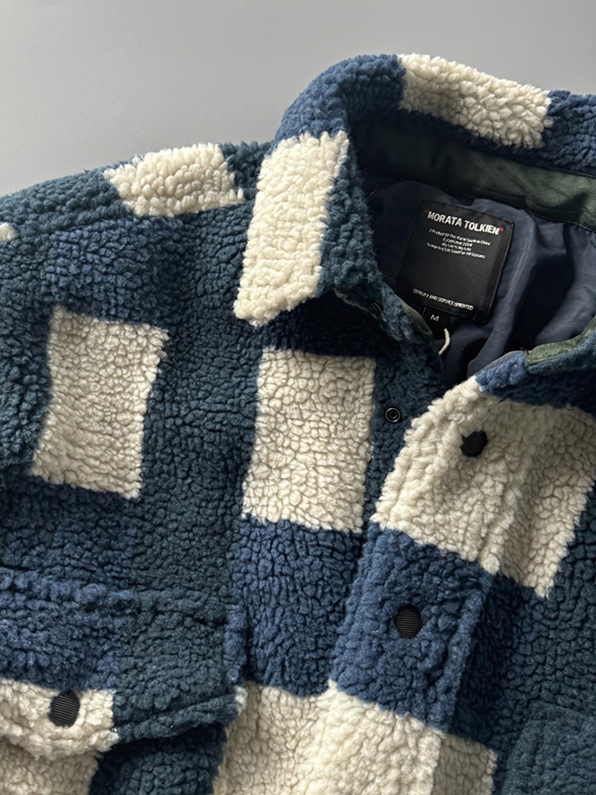 製品画像: ヴィンテージトライバルパターン シープボアシャツの正面画像、トライバルパターンが際立つデザイン。
詳細画像: シープボア素材とトライバルパターンのディテール画像、ヴィンテージ感を強調。