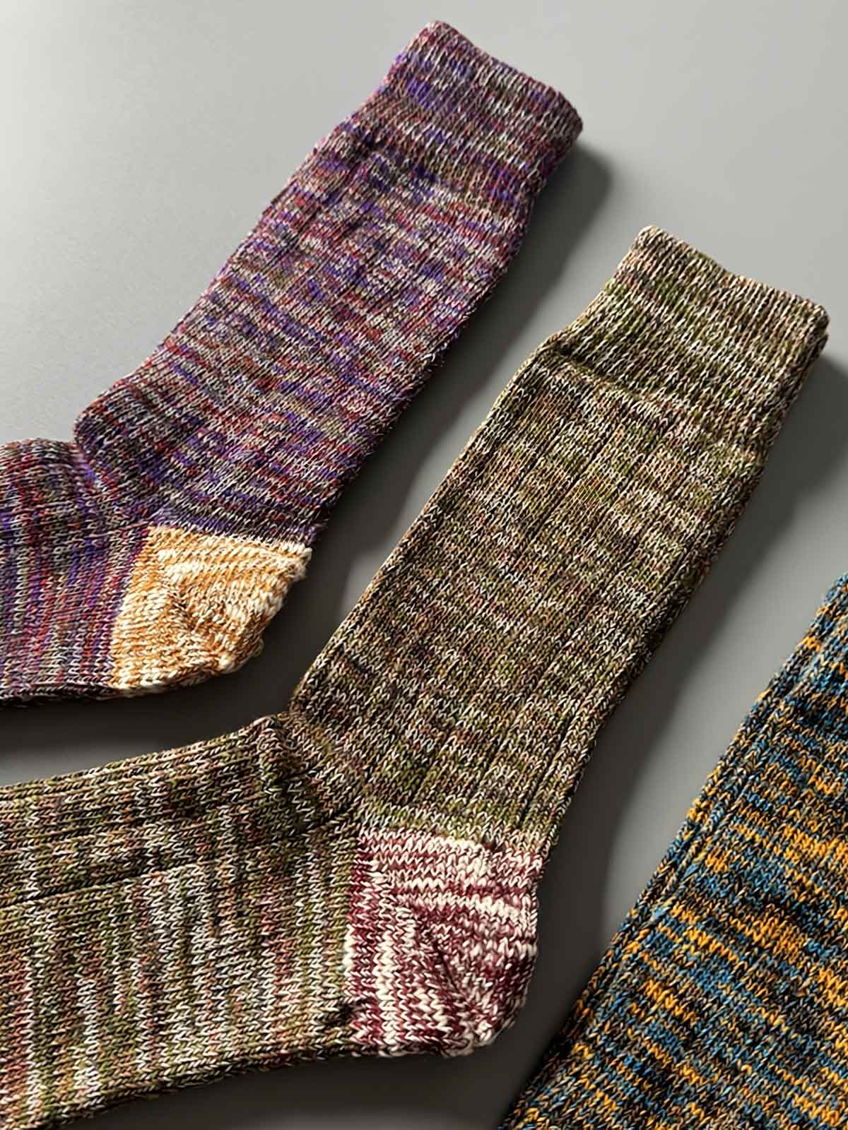 製品画像: カラーミックスヴィンテージロングソックスの5足セット展示、カジュアルで暖かいデザインが特徴。
詳細画像: カラフルなミックス糸で編まれた太糸ソックスのディテール画像、ヴィンテージ感を強調。