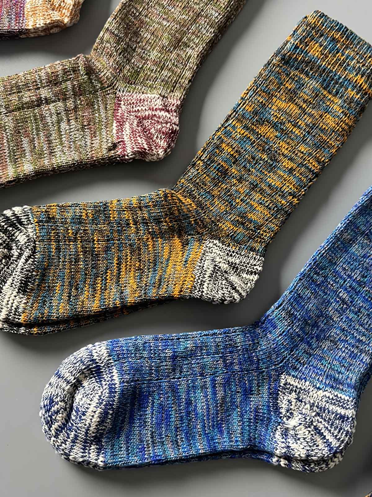 製品画像: カラーミックスヴィンテージロングソックスの5足セット展示、カジュアルで暖かいデザインが特徴。
詳細画像: カラフルなミックス糸で編まれた太糸ソックスのディテール画像、ヴィンテージ感を強調。