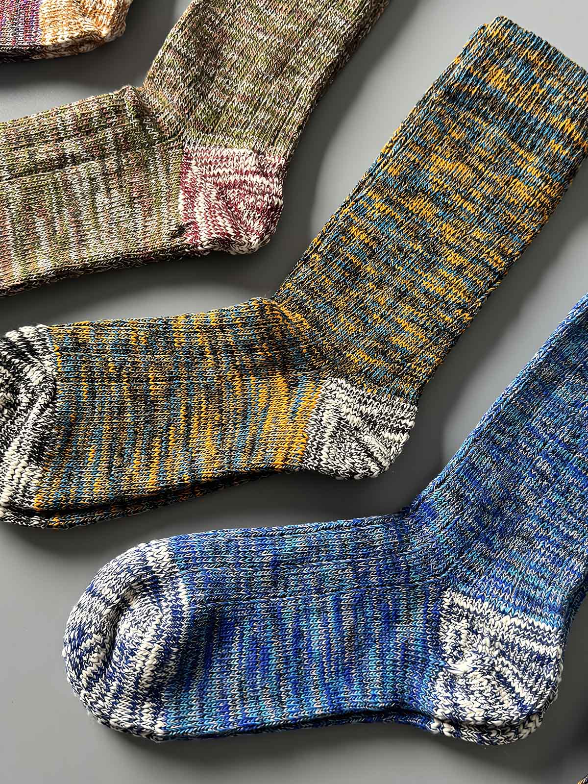 製品画像: カラーミックスヴィンテージロングソックスの5足セット展示、カジュアルで暖かいデザインが特徴。
詳細画像: カラフルなミックス糸で編まれた太糸ソックスのディテール画像、ヴィンテージ感を強調。