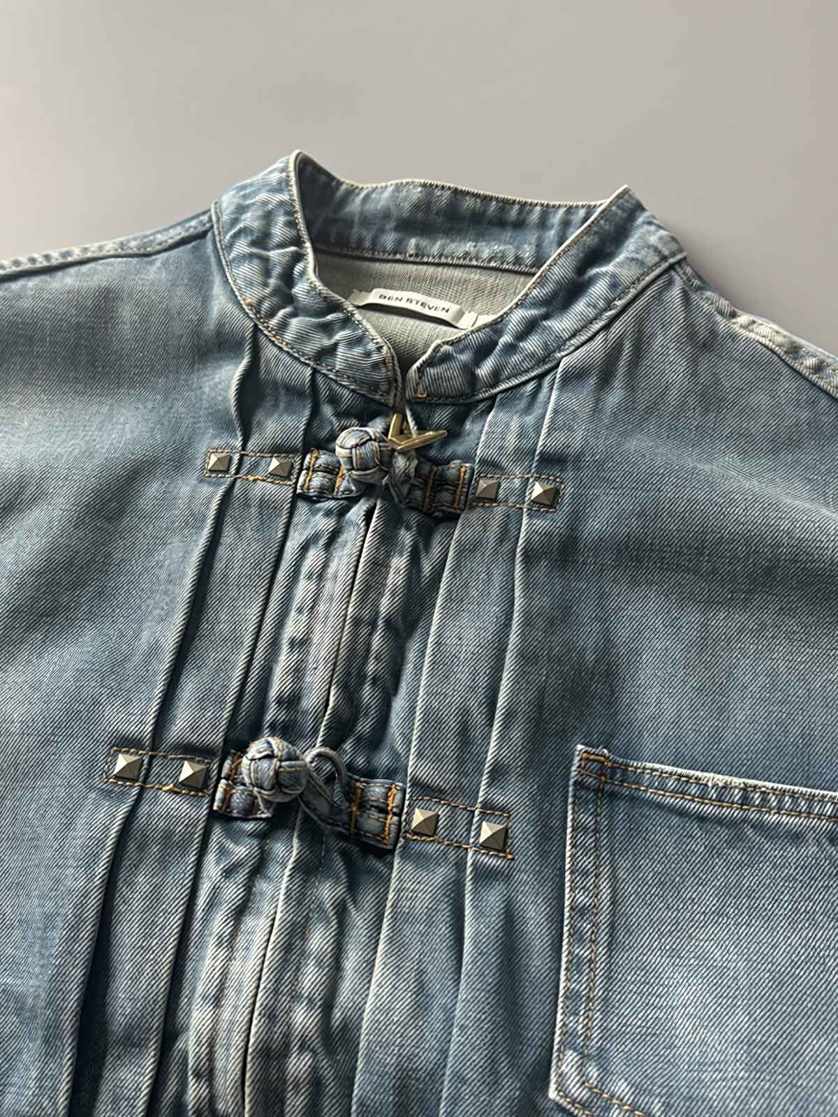 製品画像: チャイニーズボタンヴィンテージデニムジャケットの正面画像、東洋と西洋のデザインが融合したユニークなスタイル。
詳細画像: チャイニーズボタンとウォッシュ加工のディテール画像、質感を際立たせる。