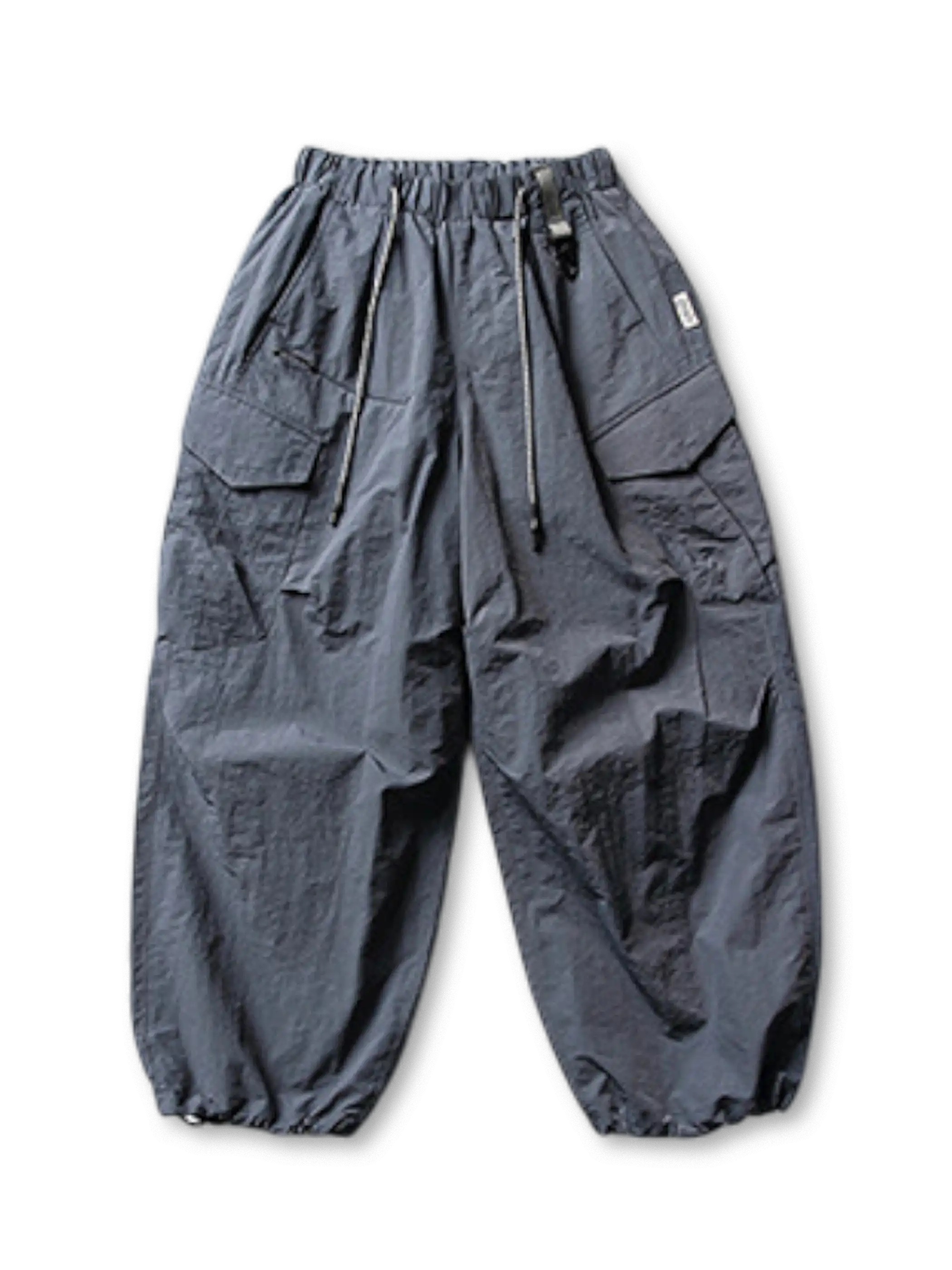 ホワイトベースのパラシュートパンツ、右サイドにジップポケットや大きめポケットが複数確認できる