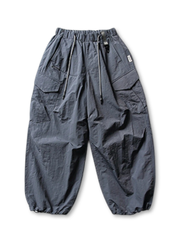 ホワイトベースのパラシュートパンツ、右サイドにジップポケットや大きめポケットが複数確認できる