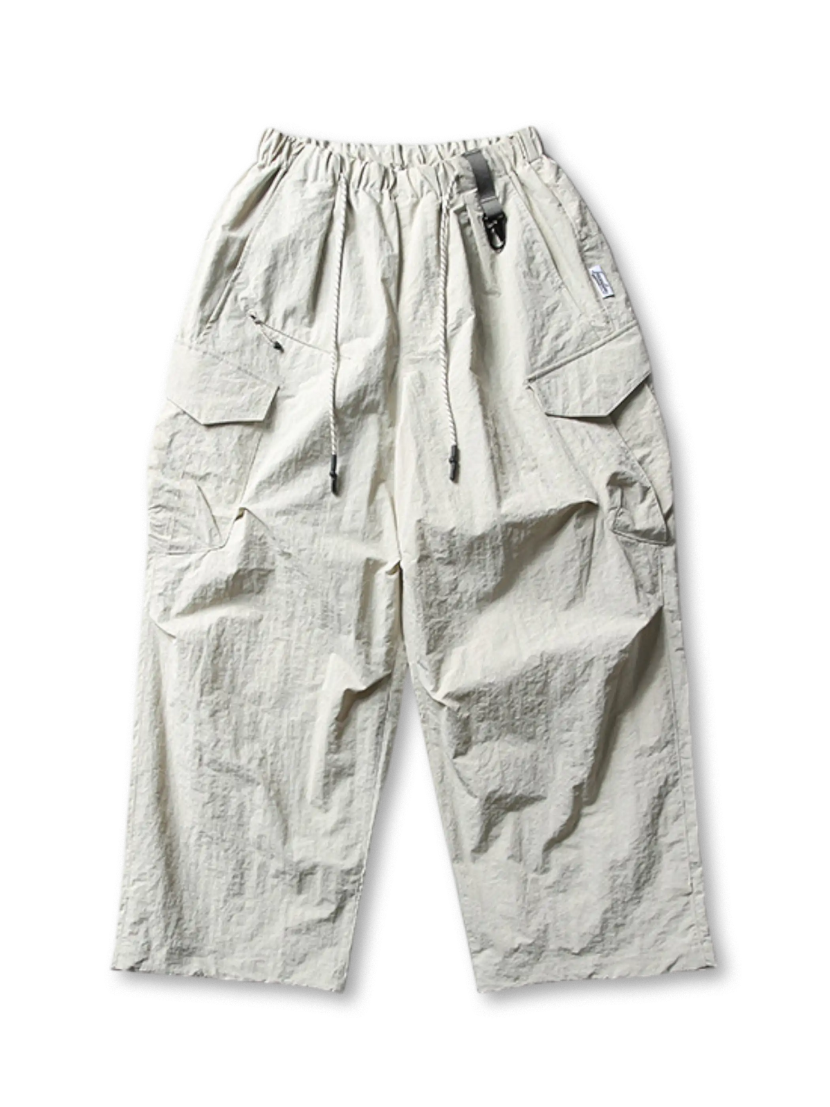 超ワイドシルエットのエアリーパラシュートパンツ。撥水・防風・速乾性に優れたナイロン生地。ゴムとドローコードのウエスト、調節可能な脚口アジャスター付き。アウトドアやストリートに最適なユニセックスデザイン。