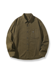 アーミーグリーンのルーズフィット長袖ワークシャツ。