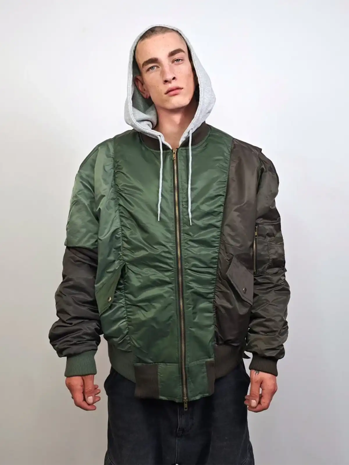 大胆なアシンメトリーパッチワークと三色バイカラー、フード付きで冬のストリートファッションに新しい風を吹き込むフライトジャケット。
