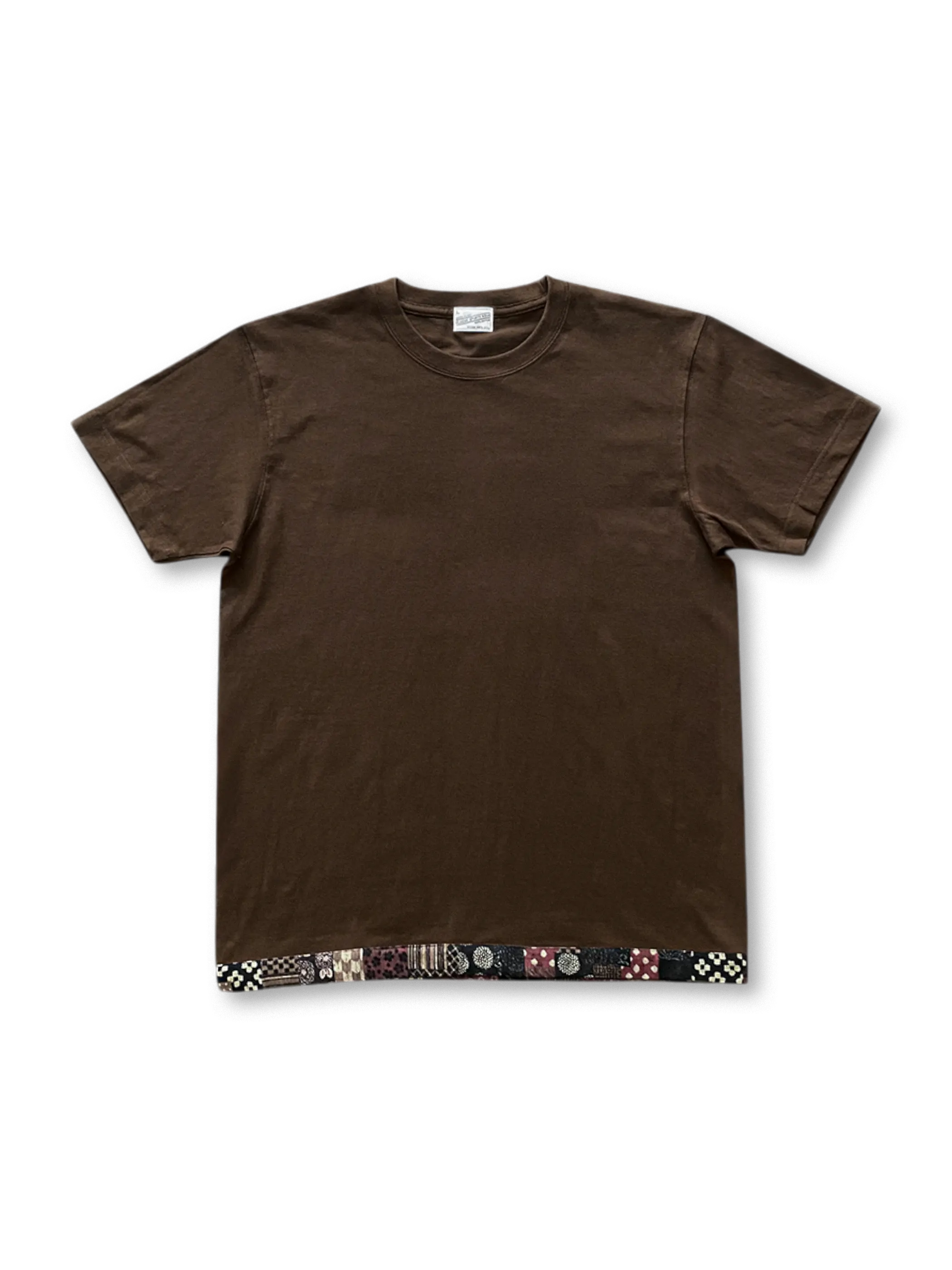 240g/m²の丸胴コットン生地に泥土色の織り染めと日本製和柄パッチを配したブラウンヘムパッチTシャツ。