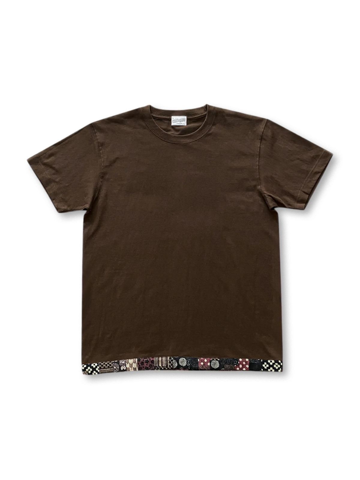 240g/m²の丸胴コットン生地に泥土色の織り染めと日本製和柄パッチを配したブラウンヘムパッチTシャツ。