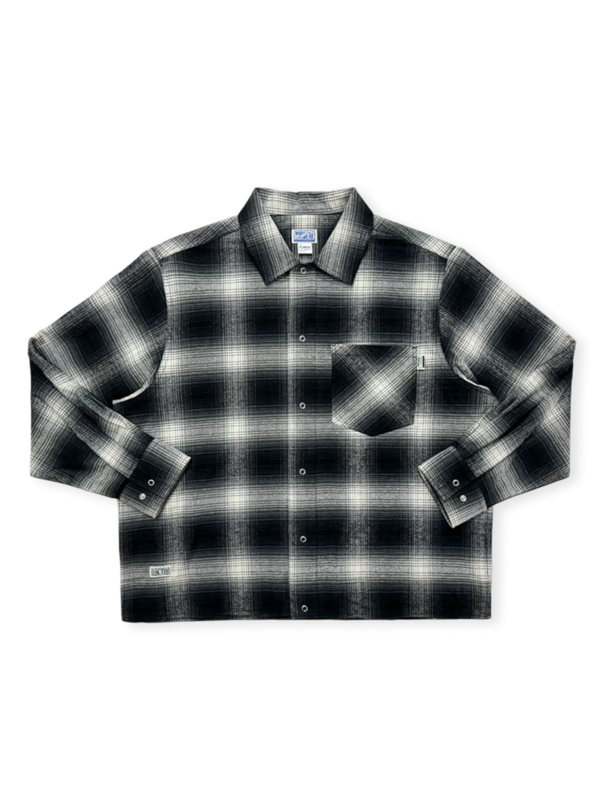 グラデーション黒白チェックのチカーノ短幅シャツ。ウォッシュ加工とYKK五爪ボタン、WORK WEARラベルが特徴。