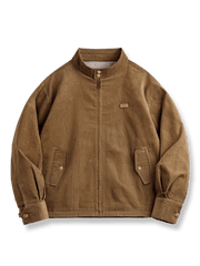 コーデュロイ素材のG9ハリントンジャケット。ダブルボタンスタンドカラー、黒白チェック裏地、ドローコード裾とフラップポケット付き。