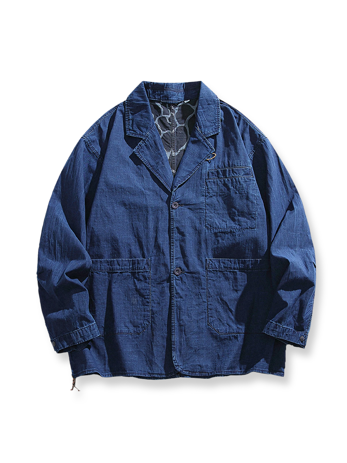 コントラスト仕立てのノッチドラペルと背面の波模様プリントが特徴のデニムテーラードジャケットの全体像。