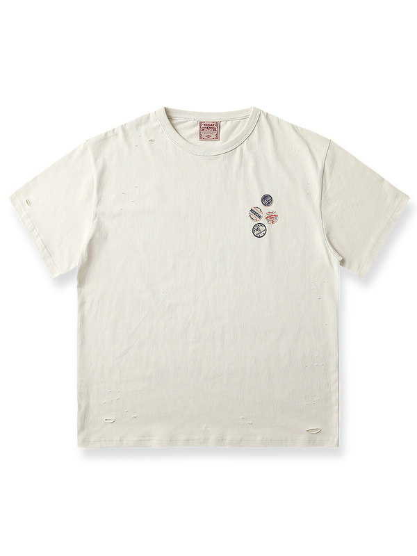 ダメージ加工とピンバッジプリントを施したミルクティーホワイトの半袖Tシャツ