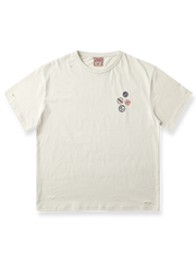ダメージ加工とピンバッジプリントを施したミルクティーホワイトの半袖Tシャツ