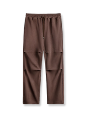 膝にダブルプリーツとシルキードレープを施したコットンポリエステル混紡のパラトルーパーパンツ。調整ゴムウエストとゆったりシルエットを特徴とするアイテム。