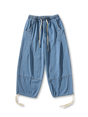 ワイドレッグラインとウエスト・裾のドローストリング付きでシルエット調整可能なヴィンテージ風デニムパンツ。丈夫なステッチと程よいフェード感が特徴。