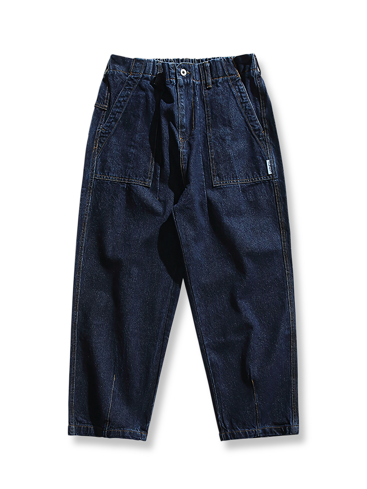 ウエストゴムと大きめ装飾ポケットを備えたゆったりシルエットのデニムパンツ。