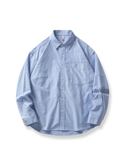 袖に精巧な刺繍が施された洗い加工コットン長袖シャツ。