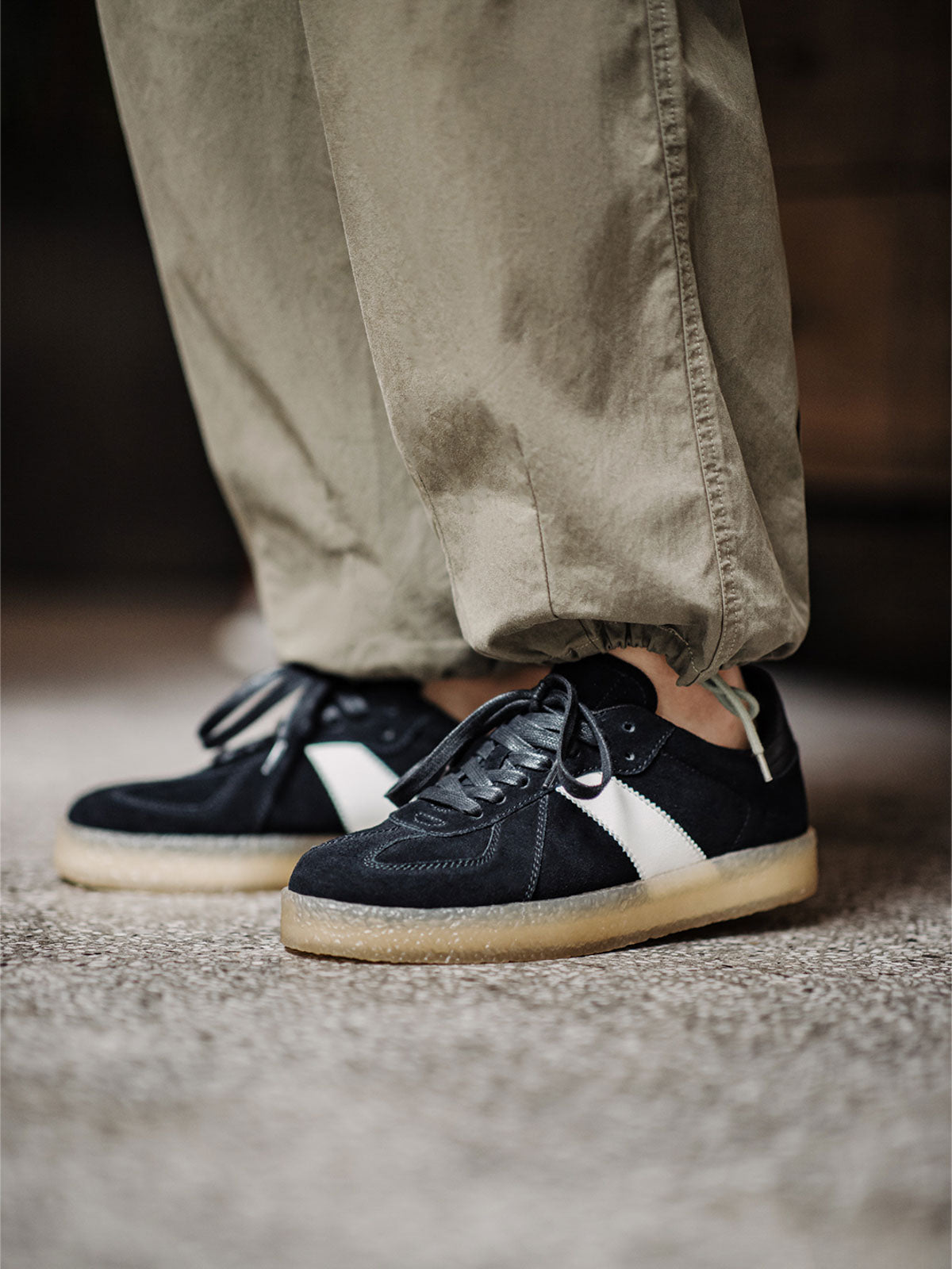 モデルがGATドイツ軍トレーニングシューズを着用し、カジュアルパンツと組み合わせている様子。