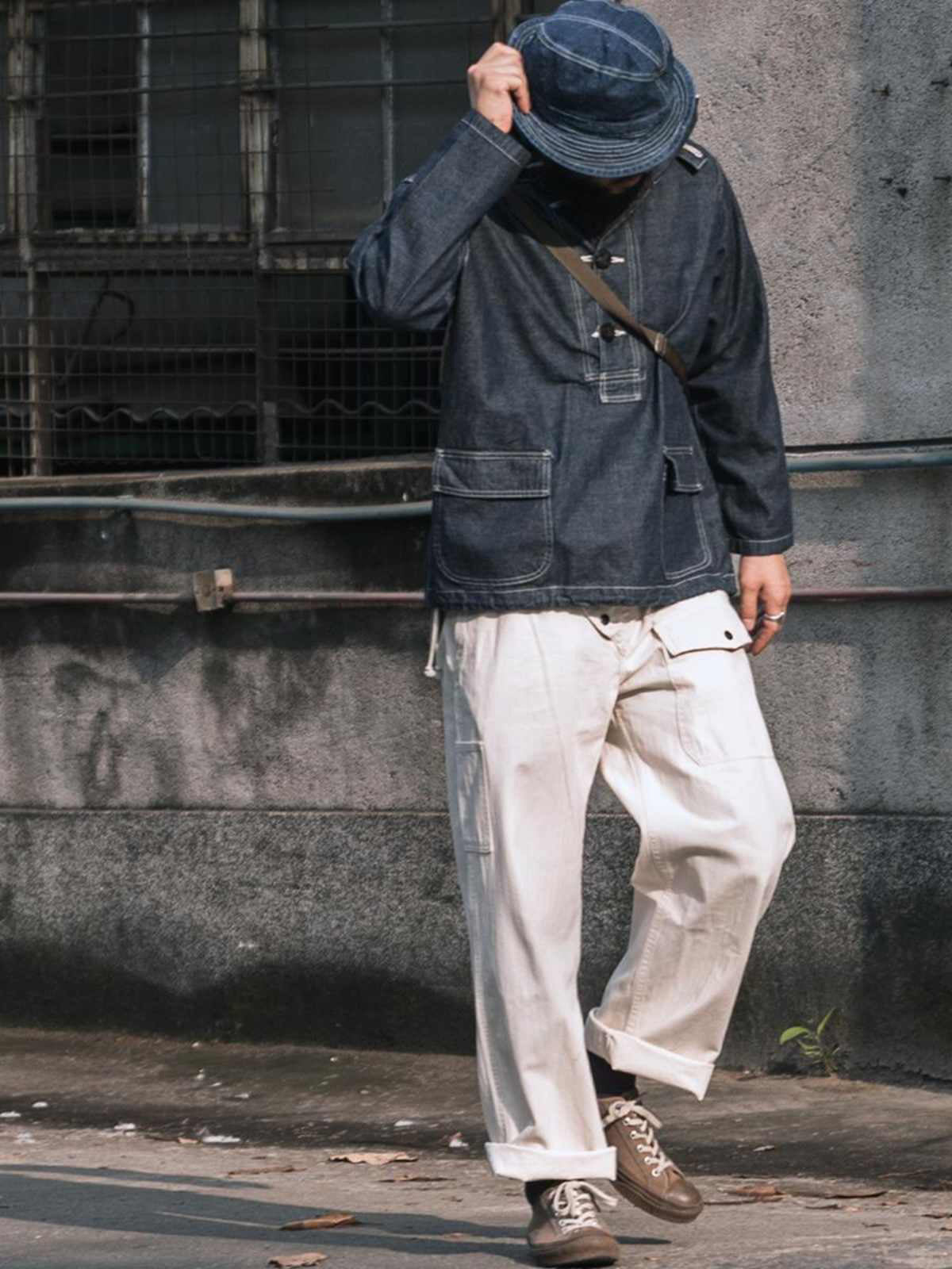 詳細画像: 大きなフードと三層前立てデザインのディテール特写。機能性とヴィンテージ感が際立つディテール。
モデル画像: モデルが迷彩柄砲兵防護プルオーバーパーカーを着用したスタイリング例。戦時風デザインを取り入れたコーディネート。