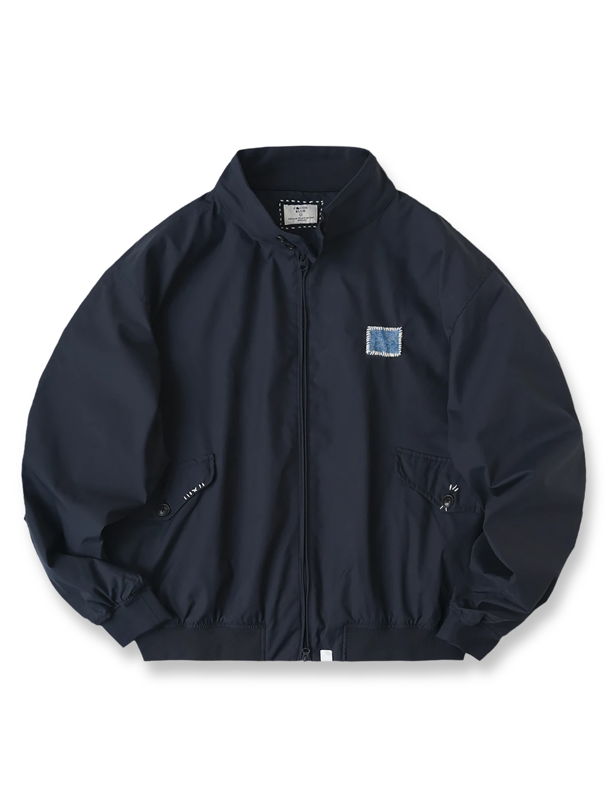 伝統的な刺し子刺繍が施されたハンドメイドのハリントンジャケット。多ポケットと隠しジップで収納力を高め、通気性ある背面オープンデザインを備えたルーズフィットジャケット。