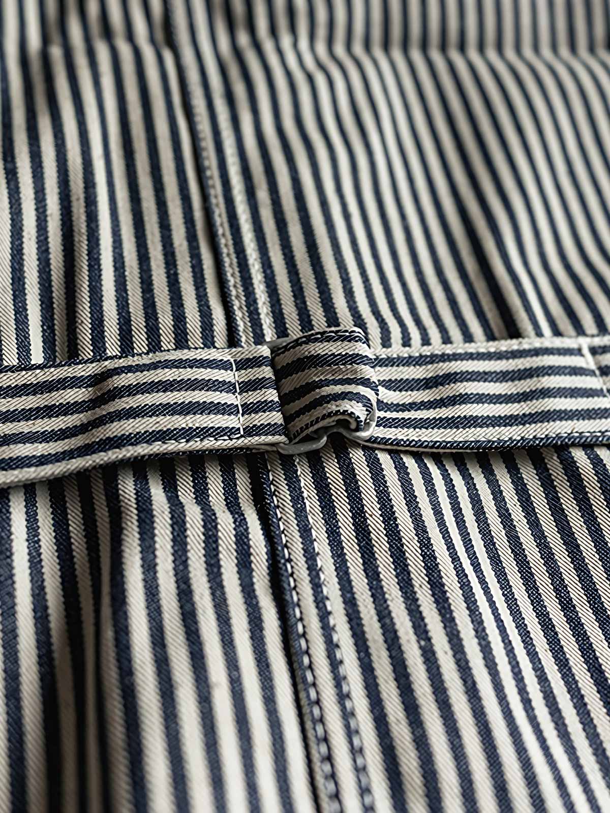 製品画像: HICKORY鉄道ストライプワークベスト 復刻バージョンの正面図。クラシックデザイン、ブルーとホワイトの縦ストライプが特徴。
詳細画像: ベストのポケットとストライプ生地のディテール。堅牢で耐摩耗性に優れたHICKORYストライプ生地を使用。