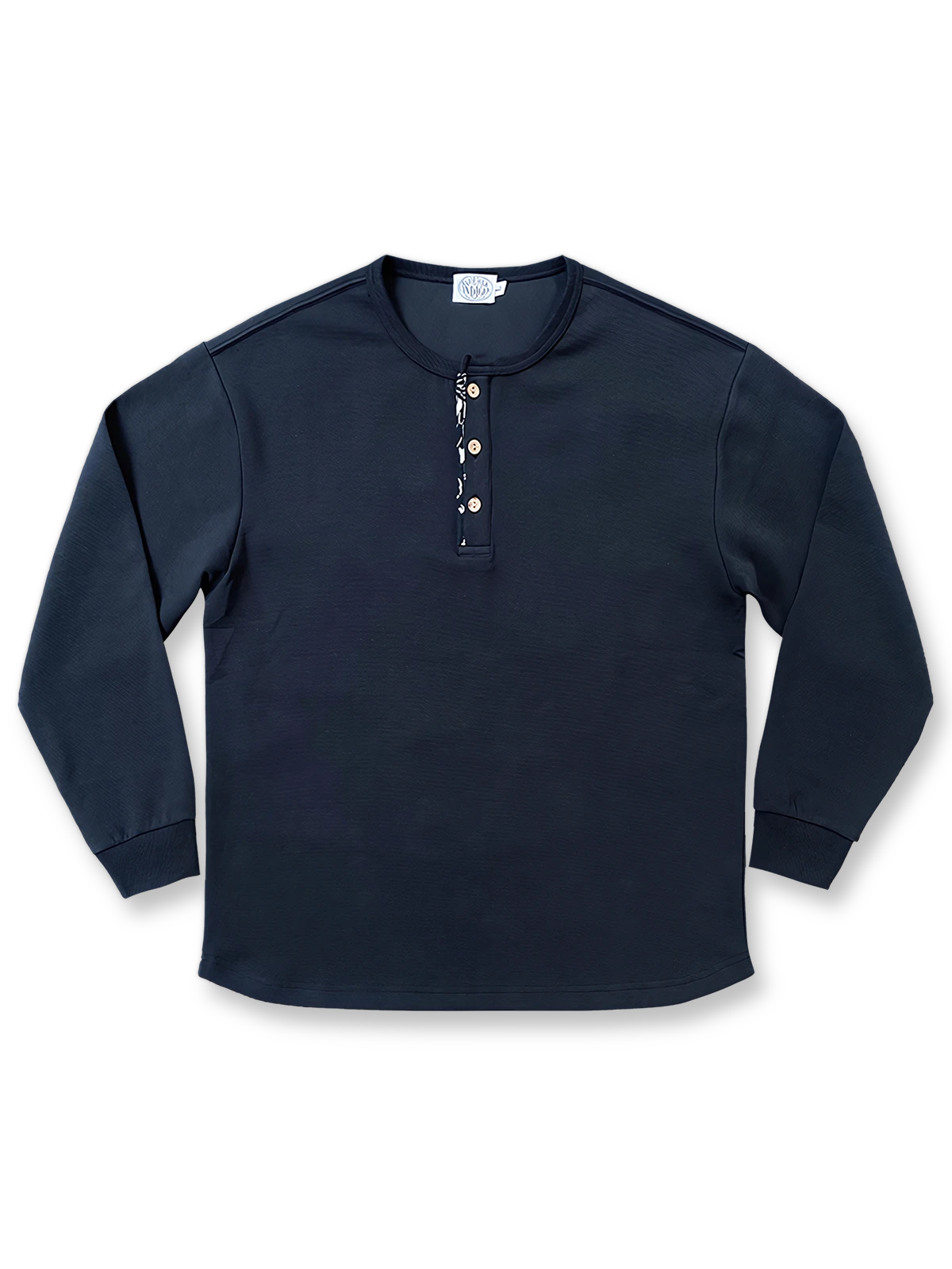 藍染古布襟とワッフル編みを施したヘンリーネック長袖Tシャツ。カーブ裾とココナッツボタンが特徴のユニセックスデザイン。