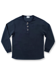 藍染古布襟とワッフル編みを施したヘンリーネック長袖Tシャツ。カーブ裾とココナッツボタンが特徴のユニセックスデザイン。