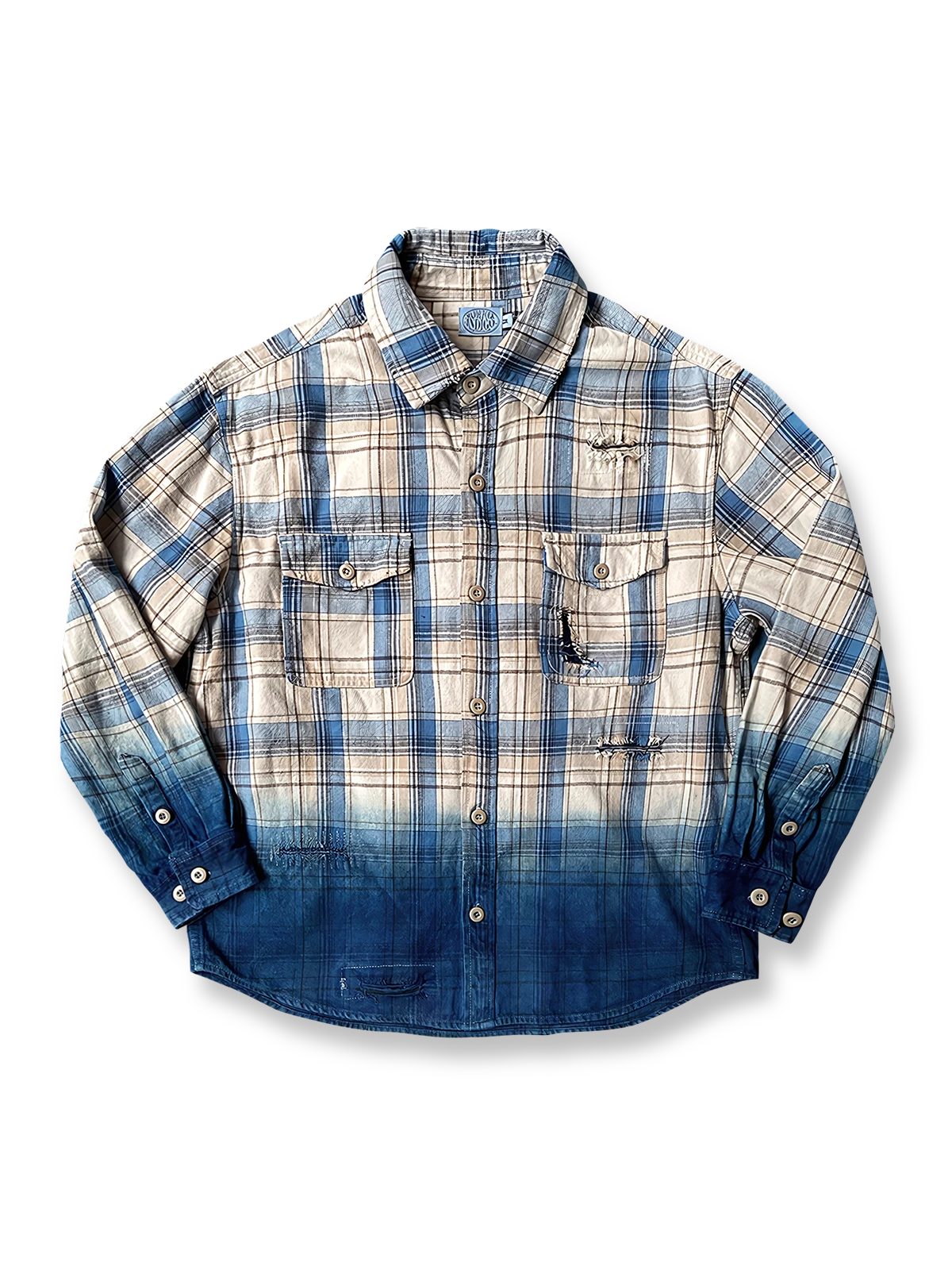 裾に向かう藍染めグラデーションとチェック柄、擦り切れ＆パッチ補強を施した長袖コットンシャツ。秋冬向けのウォッシュ加工とアークヘムを特徴とするアイテム。