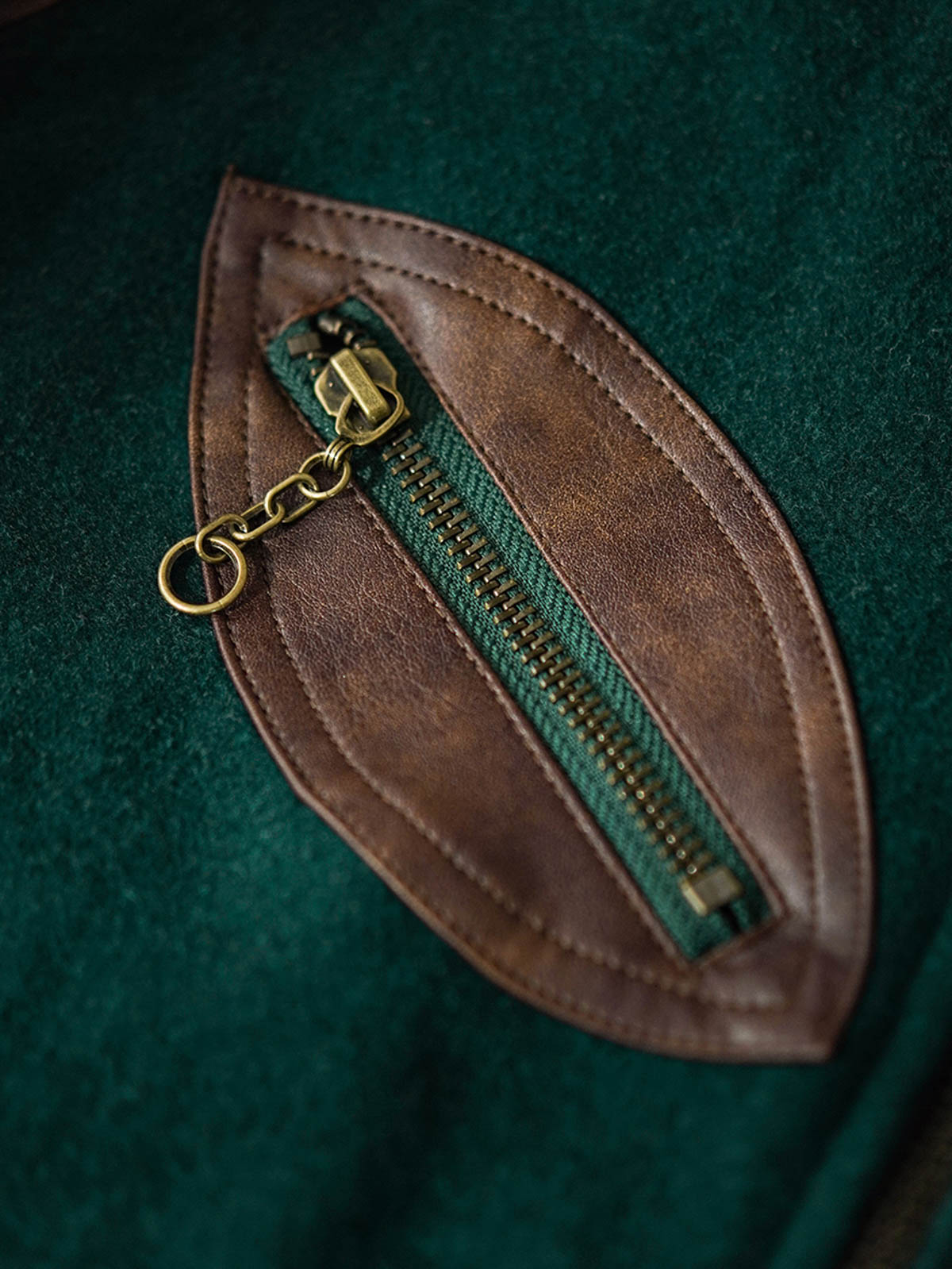 ジャケットのディテール。IDEAL社製銅製ジッパーとレザーの袖を示す。