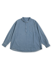 ハーフプラケットと立ち襟風襟付きのライトブルーウォッシュデニムシャツ。ゆったりシルエットとヴィンテージポケット付き。