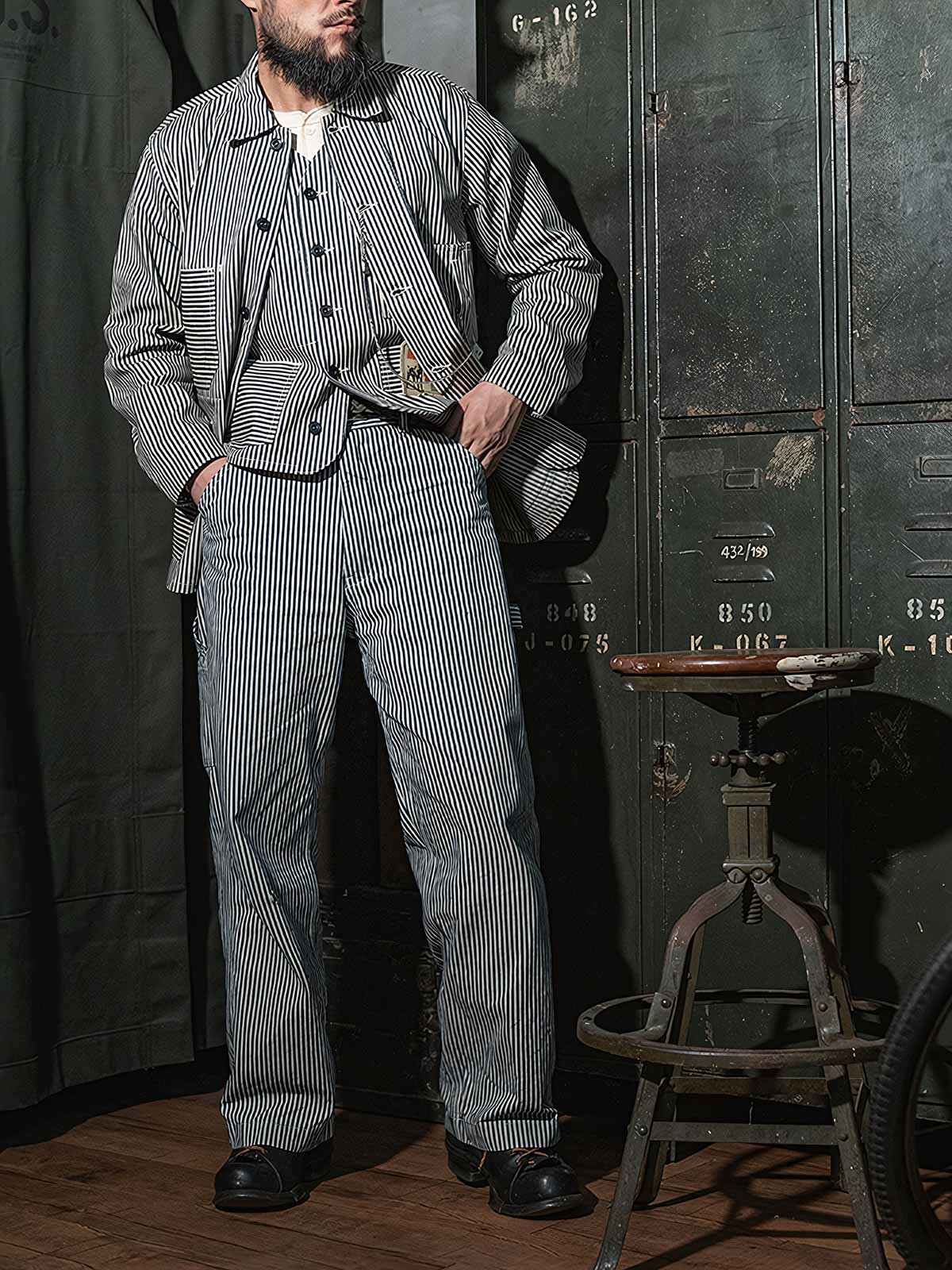 詳細画像: セルビッジ仕上げとブルー・ホワイトストライプのディテール。耐久性の高い11.5oz-12ozのデニム生地、ヴィンテージ感漂うデザイン。
モデル画像: モデルが着用するLOT421 HICKORY鉄道ストライプワークパンツのスタイリング例。レトロなワークウェア、クラシックファッションのコーディネートに最適。