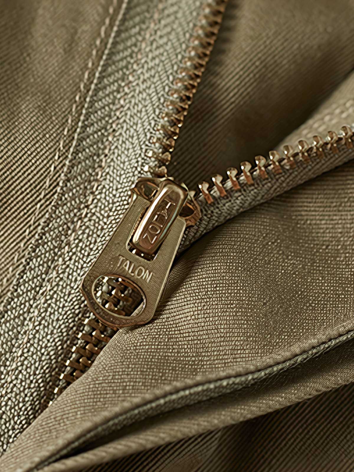 製品画像: M-42パラシュートジャケットの正面画像。ヴィンテージミリタリースタイルが際立つ高光沢ツイルコットンジャケット。
詳細画像: ジャケットのポケットとウエストベルトのディテール。機能性とデザイン性を兼ね備えたディテール。