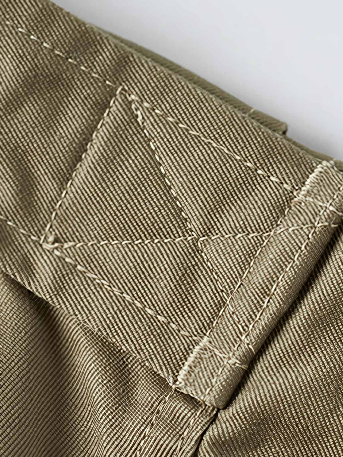 製品画像: M-42パラシュートジャケットの正面画像。ヴィンテージミリタリースタイルが際立つ高光沢ツイルコットンジャケット。
詳細画像: ジャケットのポケットとウエストベルトのディテール。機能性とデザイン性を兼ね備えたディテール。